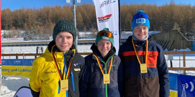 Valentin Müller, Yannick Schraag und Paul Achatz lächeln nach der Staffel-Siegerehrung mit ihren Goldmedaillen in die Kamera.