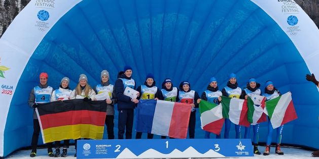 Die Flower Ceremony des Mixed-Staffel-Wettbewerbs: Das französische Team in der Mitte, rechts Deutschland, links Italien. Alle halten ihre Nationalflaggen in den Händen.